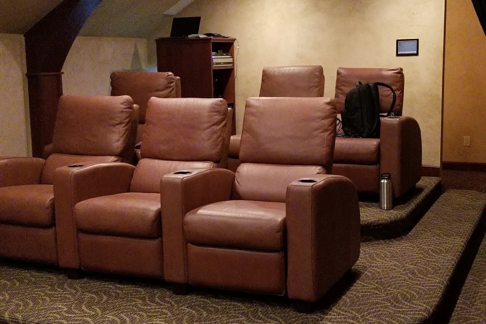 Attic cinema room with a curved barrel-vaulted ceiling and tan leather recliners