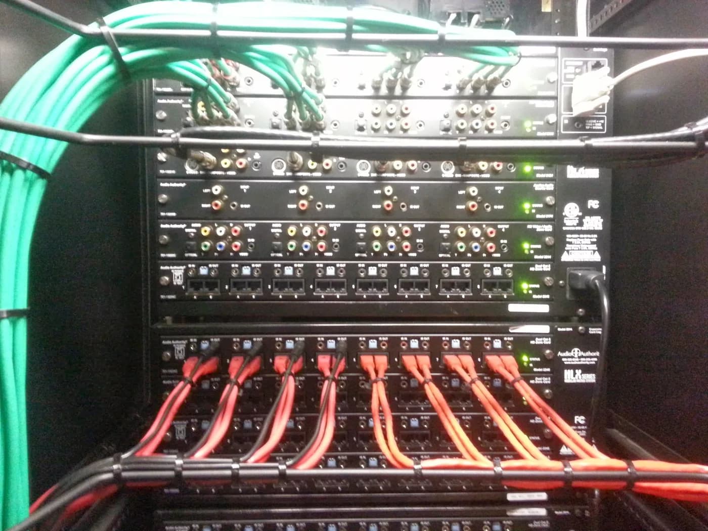 Patch panel terminated with colour-coded green and red network cabling