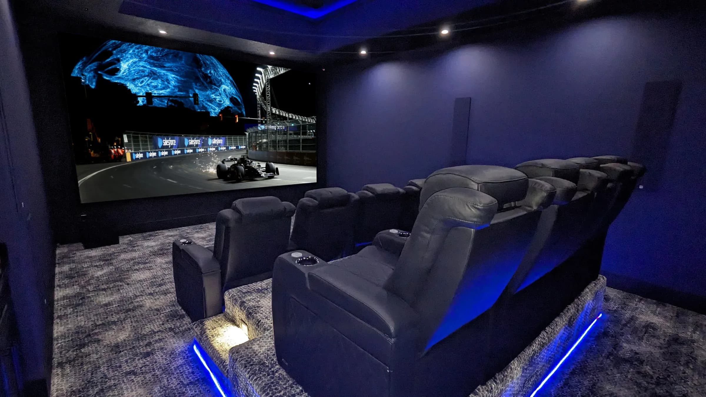 Private cinema room with tiered seating, acoustic treatment and a projection screen